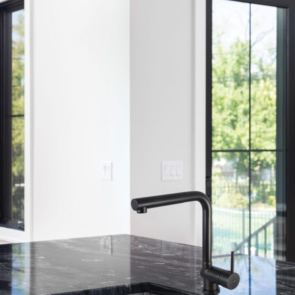 A modern kitchen black stainless faucet detail on an island with